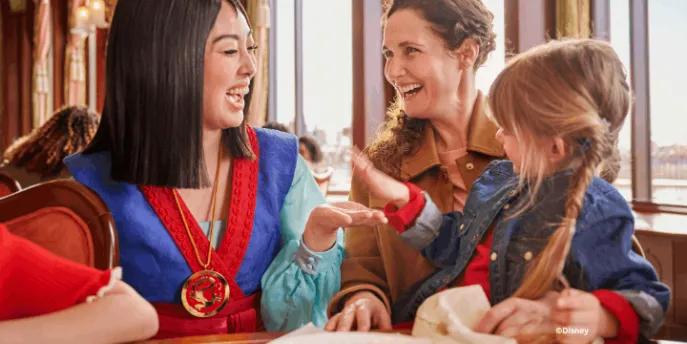 Mulan interacting with a mother and young girl during character dining at The Regal View Restaurant & Lounge