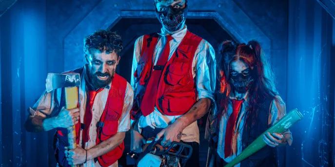 Three intimidating actors holding weapons in a blue-lit corridor