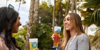 Two women smiling and drinking beer at the Seven Seas Food Festival