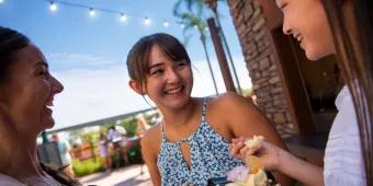 EPCOT International Flower and Garden Festival Three young women smiling while eating food at EPCOT