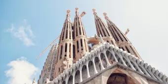 Looking up at the large towers of the Sagrada Familia in front of a blue sky