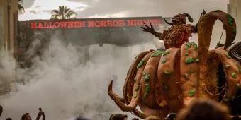 The Pumpkin Lord standing in a giant pumpkin in front of a Halloween Horror Nights sign