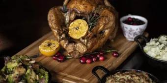 A roast turkey stuffed with lemon and herbs, with stuffing, mashed potatoes and brussel sprouts