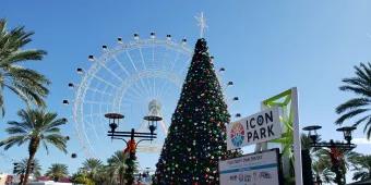 A large Christmas tree in front of The Wheel at ICON Park
