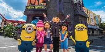 Characters from Despicable Me, including two Minions and Gru, standing outside Despicable Me Minion Mayhem