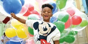 Kind mit Ballons im Magic Kingdom Park Kind mit Ballons im Magic Kingdom Park
