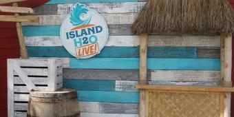 A photo backdrop of weathered shiplap boards, wooden crates and a beach hut