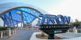 The TRON Lightcycle/Run sign with the ride and large futuristic canopy overhead