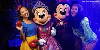 Guests dressed as Snow White and one of the Seven Dwarfs meeting Mickey and Minnie in their Halloween costumes