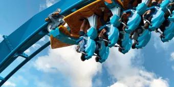Pipeline: The Surf Coaster A close-up image of riders on a coaster at the point of inversion