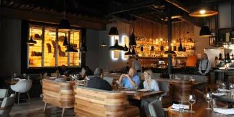 People sitting at a table in a restaurant with a bar in the background