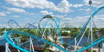 A computer-generated image of a rollercoaster with a light blue track and a yellow ride vehicle going over a drop