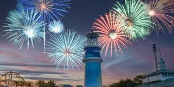SeaWorld Summer Spectacular Multi-coloured fireworks being set off above a lighthouse as the sun is setting