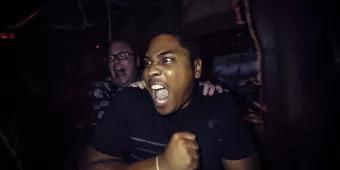 Two men in a haunted house screaming at something to their right
