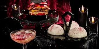 Food and Drink at Halloween Horror Nights 2023 Snowball cakes, a double cheeseburger with a red bun and a cocktail against a black and red background