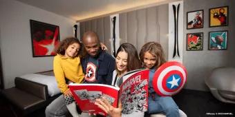 A family of 4 sat on a bed reading a Marvel comic 