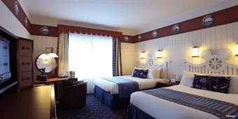 Disney Newport Bay Club A nautical themed hotel room with two double beds and a dresser