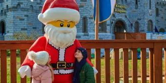 A boy and a girl looking up at LEGO Santa