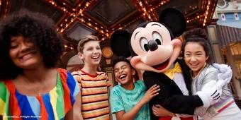 Walt Disney World Resort in Florida Mickey Mouse hugging and posing with 4 young adults