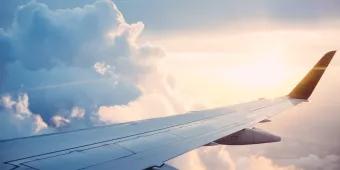 A view out of a plane window of a plane wing in the clouds