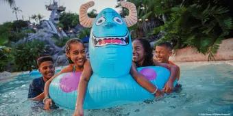 Four children in a lazy river with a pool float designed to look like Sully from Monsters Inc