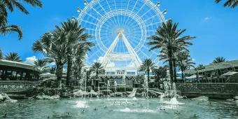 ICON Park Wheel Large white ferris wheel with fountains in front and palm trees. Beneath the wheel is a sign which says SEA LIFE.