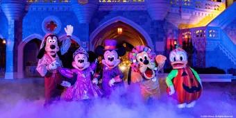 Mickey, Minnie, Goofy, Pluto and Donald Duck posing in Halloween costumes