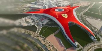 A large red building shaped in a triangle with a large yellow badge on it with a black horse on top which is the Ferrari badge. There are roads and rollercoasters coming out of this large building.