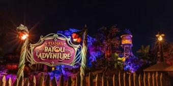 Tiana's Bayou Adventure The sign for Tiana's Bayou Adventure lit up at night in front of the attraction