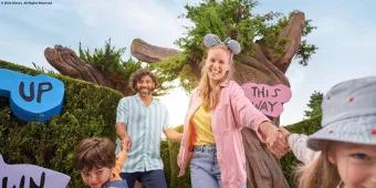 Disneyland Paris A mum and dad being dragged towards the camera by their son and daughter in the middle of a hedge maze