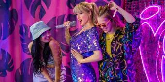 Two women posing with a Taylor Swift waxwork at Madame Tussauds London