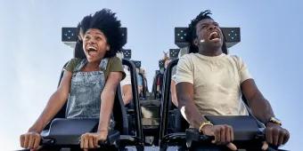 VelociCoaster in Universal Islands of Adventure Two people screaming on a rollercoaster with only lap bars holding them in. They are looking down in shock ready to fall.