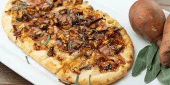 Herbstpizza Eine lange Pizza, belegt mit herbstlichen Zutaten