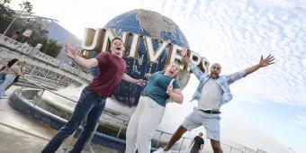 Universal Orlando Resort Three people jumping excitedly in front of the Universal Globe