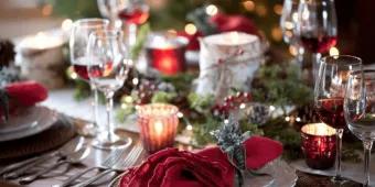 Christmas meal at Raglan Road Christmas dinner table set with plates, crackers and Christmas tree lights in the background.