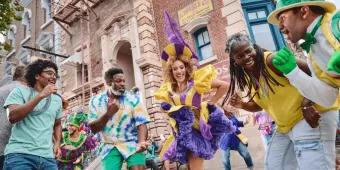 Mardi Gras im Universal Orlando Resort Menschen tanzen mit Mardi Gras Künstlern in bunten, mit Federn geschmückten Kostümen