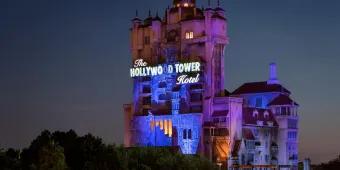 The Twilight Zone Tower of Terror A large creepy looking tower standing tall above trees which looks like a run down, creepy hotel with a sign lit saying the Hollywood Tower Hotel.