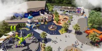 Misty theme park with spinning rides, lego statues and a large building with space theming on it.