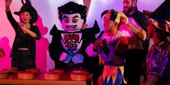 LEGOLAND Dubai Halloween Dracula lego character danging by lego dj deck with kids gethered around wearing halloween costumes.