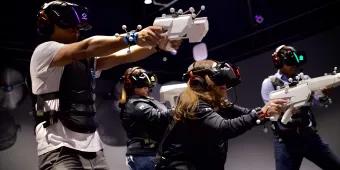 Sandbox VR in Orlando A group of adults shooting fake guns in a VR experience