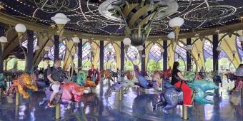 People sat on a carousel made of hand carved animals, including lions, bulls and other animals associated with zodiac signs.