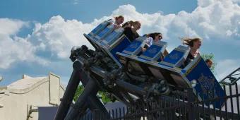 Families riding a thrilling roller coaster at a theme park