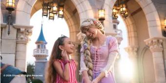 A young girl meeting Rapunzel in front of the castle at Disney World