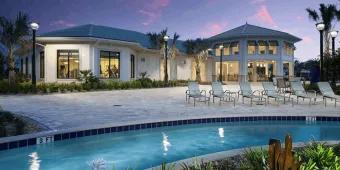 Lazy river and clubhouse with lounge chairs at Storey Lake Resort during dusk
