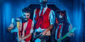 Three intimidating actors holding weapons in a blue-lit corridor