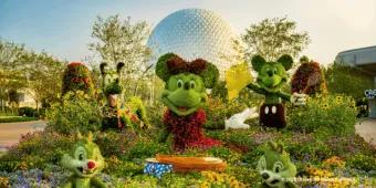 Topiaries of Mickey, Minnie, Pluto, Chip, and Dale set in a colorful garden bed in front of Spaceship Earth
