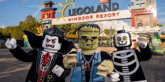 Three costumed Lego Halloween characters standing in front of the Legoland Windsor Resort entrance