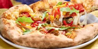 A slice of Harvest Moon pizza with fresh toppings being lifted from a plate at Pizza Moon in Universal Epic Universe