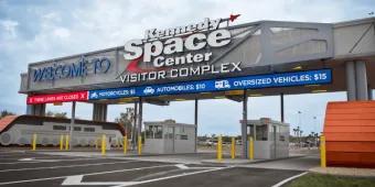 The parking toll booths and welcome sign at the entrance to the Kennedy Space Center Visitor Complex
