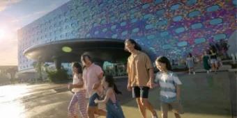 Parents with their three kids walking together in the sun in front of Universal Stella Nova Resort
